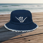 Navy blue bucket hat with white fringe on a beachseide boardwalk