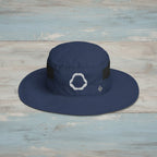 Navy blue wide-brimmed hat with a shark jaws embroidery on a rustic wood background 