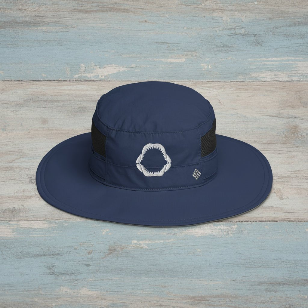 Navy blue wide-brimmed hat with a shark jaws embroidery on a rustic wood background 