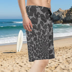 Dude wearing shark pattern board shorts on La Jolla Beach.