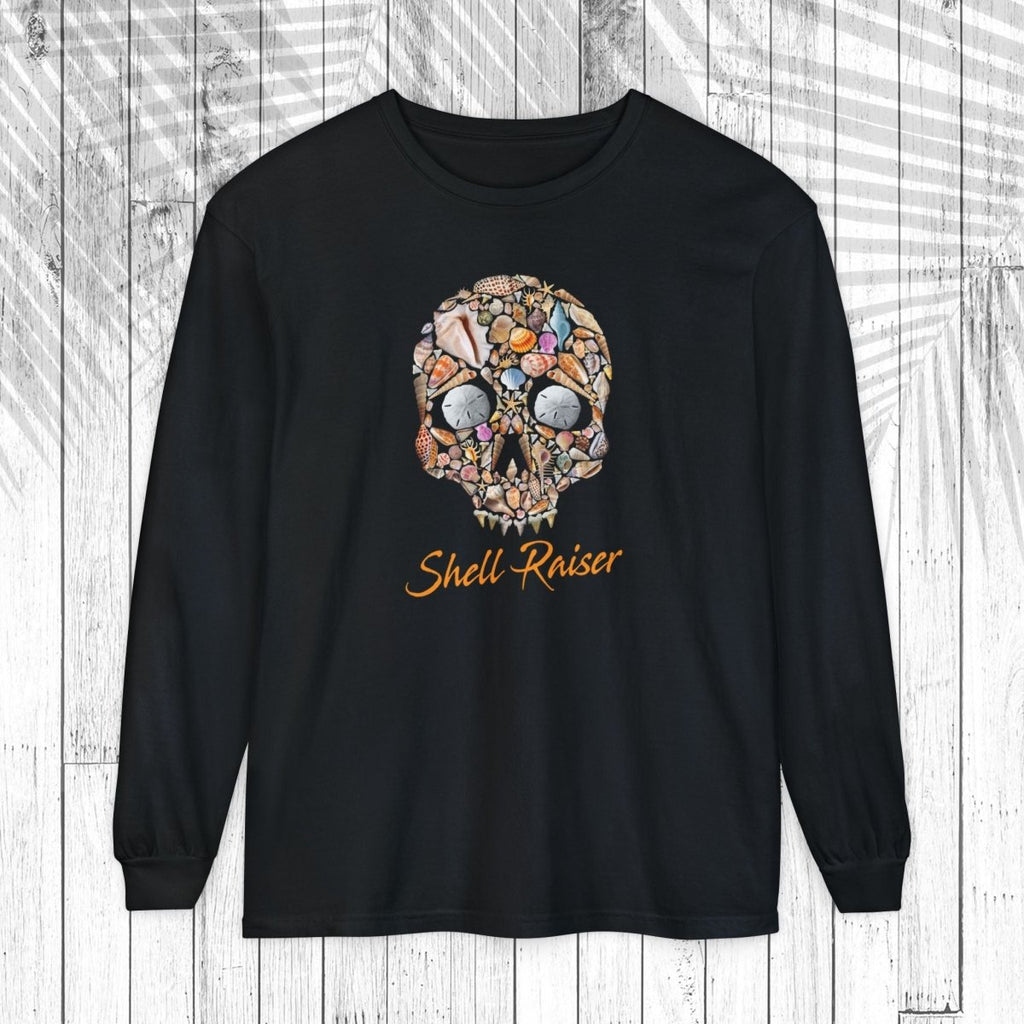 A black long-sleeve t-shirt with a colorful skull graphic made of various small objects and the text 'Shell-Raiser' in orange cursive, displayed on a white wood plank background.