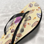 Flip-flop with shell pattern on a sandy background