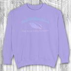 Purple sweatshirt with text and fish graphic on a wooden background