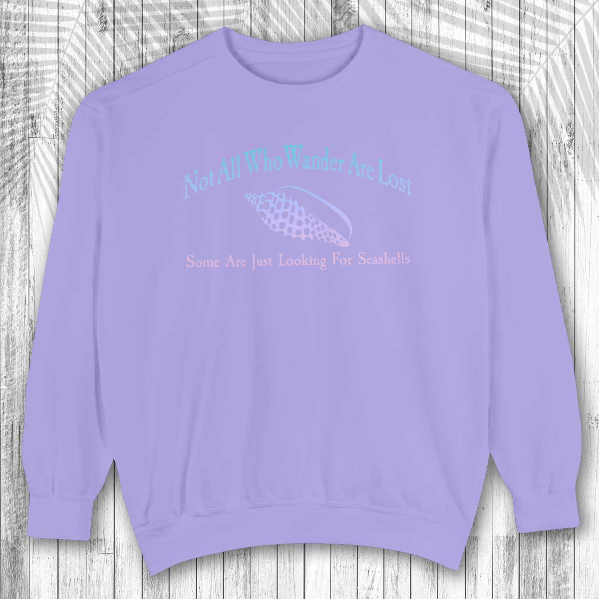 Purple sweatshirt with text and fish graphic on a wooden background
