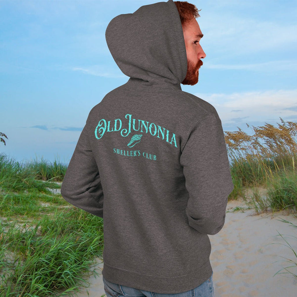 Person wearing a gray hoodie with 'Old Junonia' text on a beach
