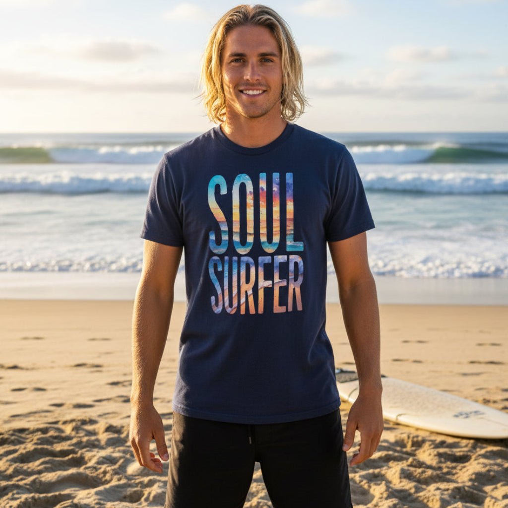 Soul Surfer Dude wearing dark purple short-sleeve Soul Surfer T-Shirt with letters printed in a colorful beach scene