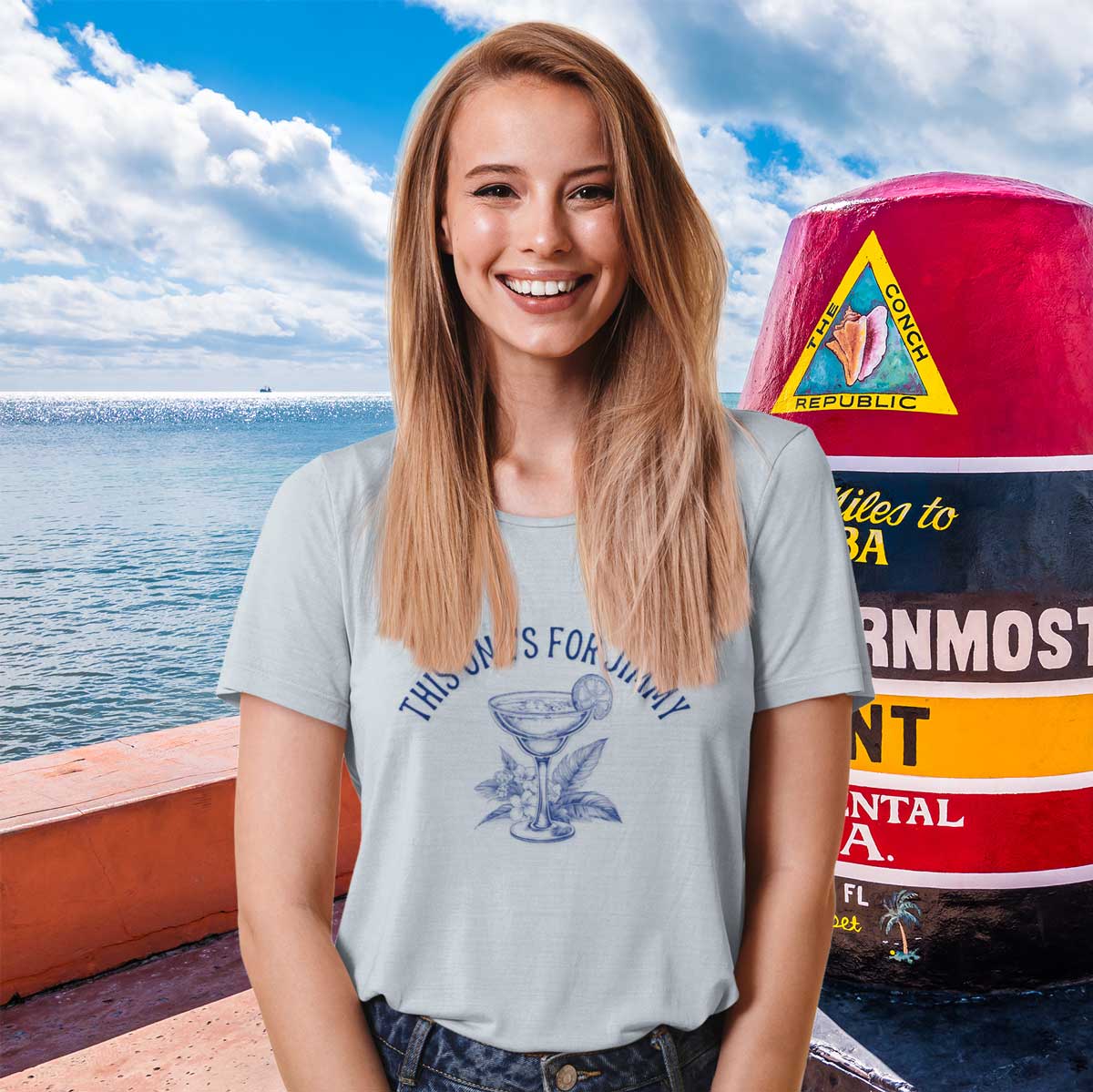 Woman standing next to the Southernmost point marker in Key West wearing a This One's For Jimmy Margarita tee