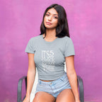 Woman wearing a gray t-shirt with 'It's 5 o'clock somewhere' text against a purple background