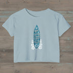 Stonewash Denim blue cropped t-shirt with funny surfer text on a rustic wood  background