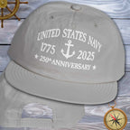 Gray cap with 'United States Navy 1775-2025 250th Anniversary' text on a wooden background.