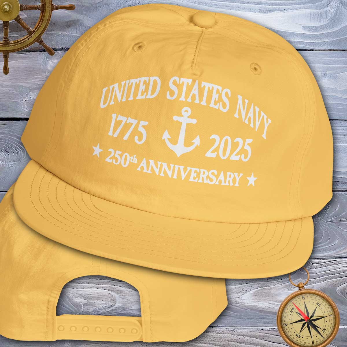 Yellow cap with 'United States Navy 1775-2025 250th Anniversary' text on a wooden background.