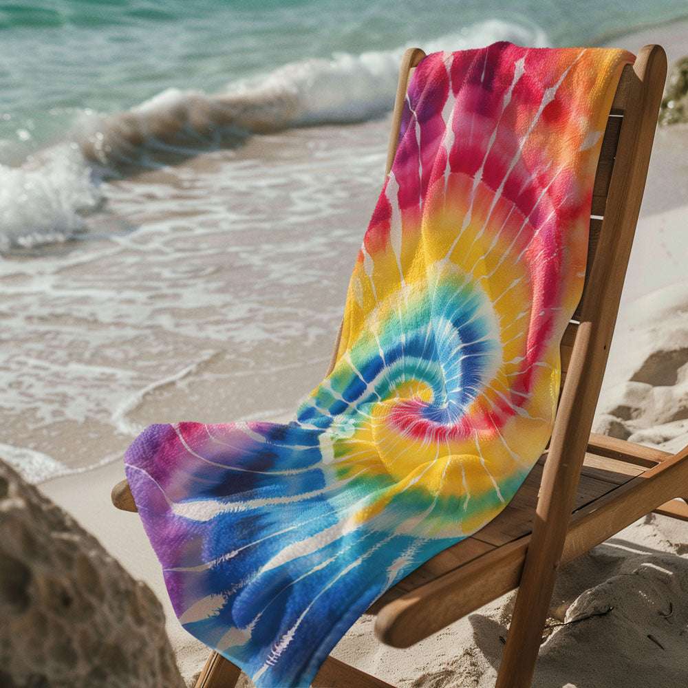 Tie Dye Beach Towel laid across a beach chair near the edge of the sea