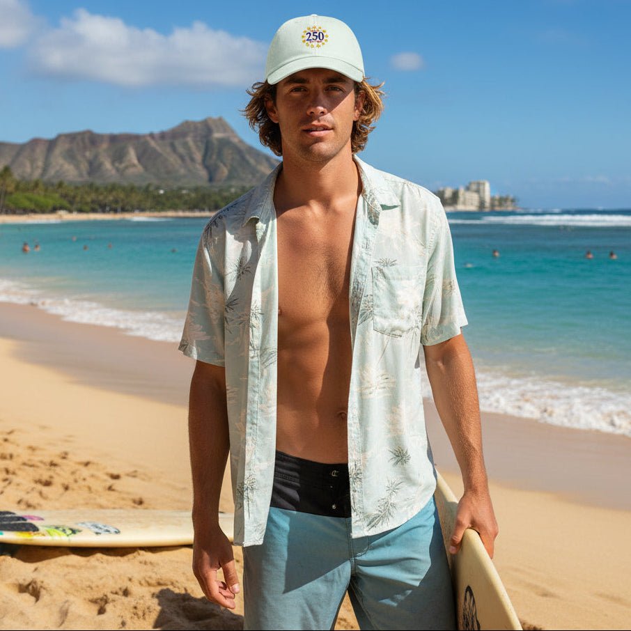 Man on a beach holding a surfboard with Diamond Head in the background