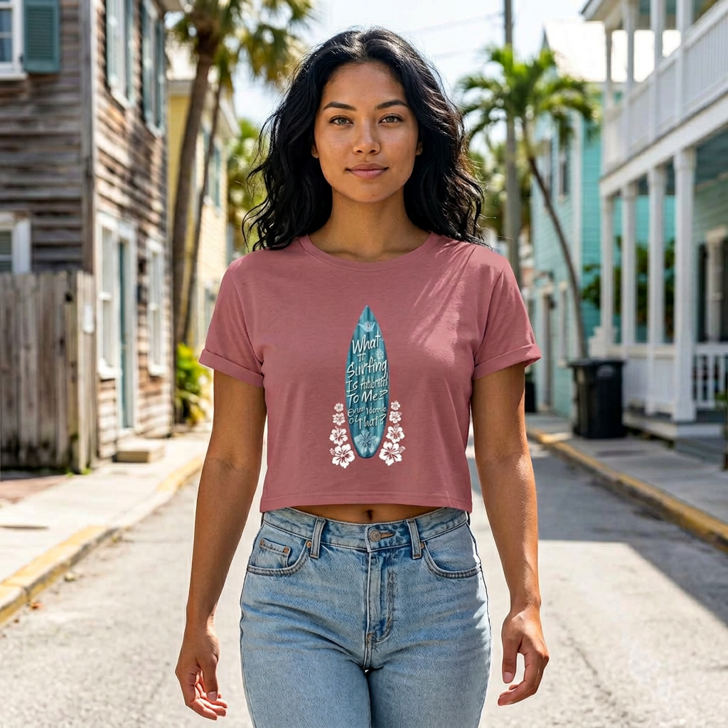 Woman wearing a pink t-shirt with a graphic design on a street with palm trees and houses.