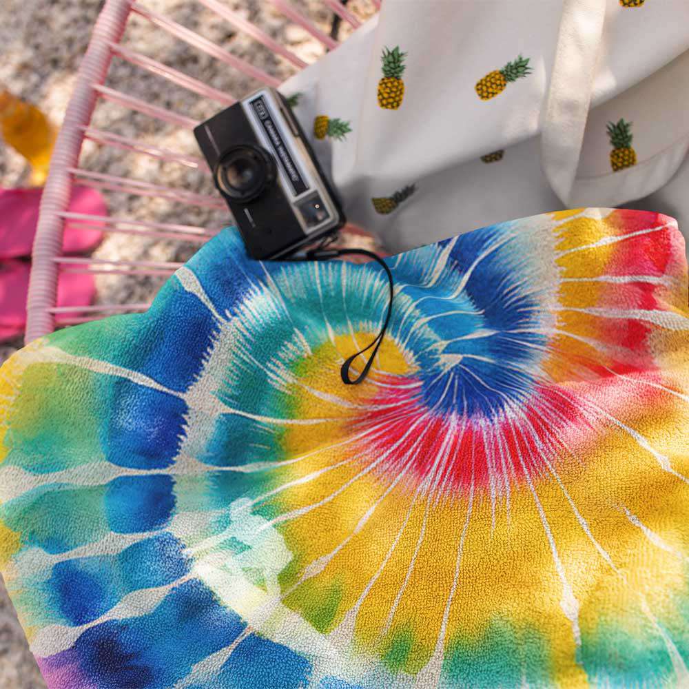 close up of beach towel showing the silhouette of a surfer riding the tie-dye curl