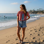 Red t-shirt with a blue surfboard graphic and text on a beautiful woman standing on La Jolla Beach