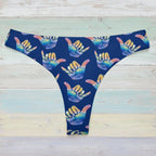 Blue surf bikini bottoms with colorful hand signs on a faded wood background
