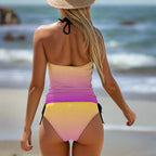 Swimsuit model wearing a colorful gradient tankini with a straw hat watching the tide come in on a California beach