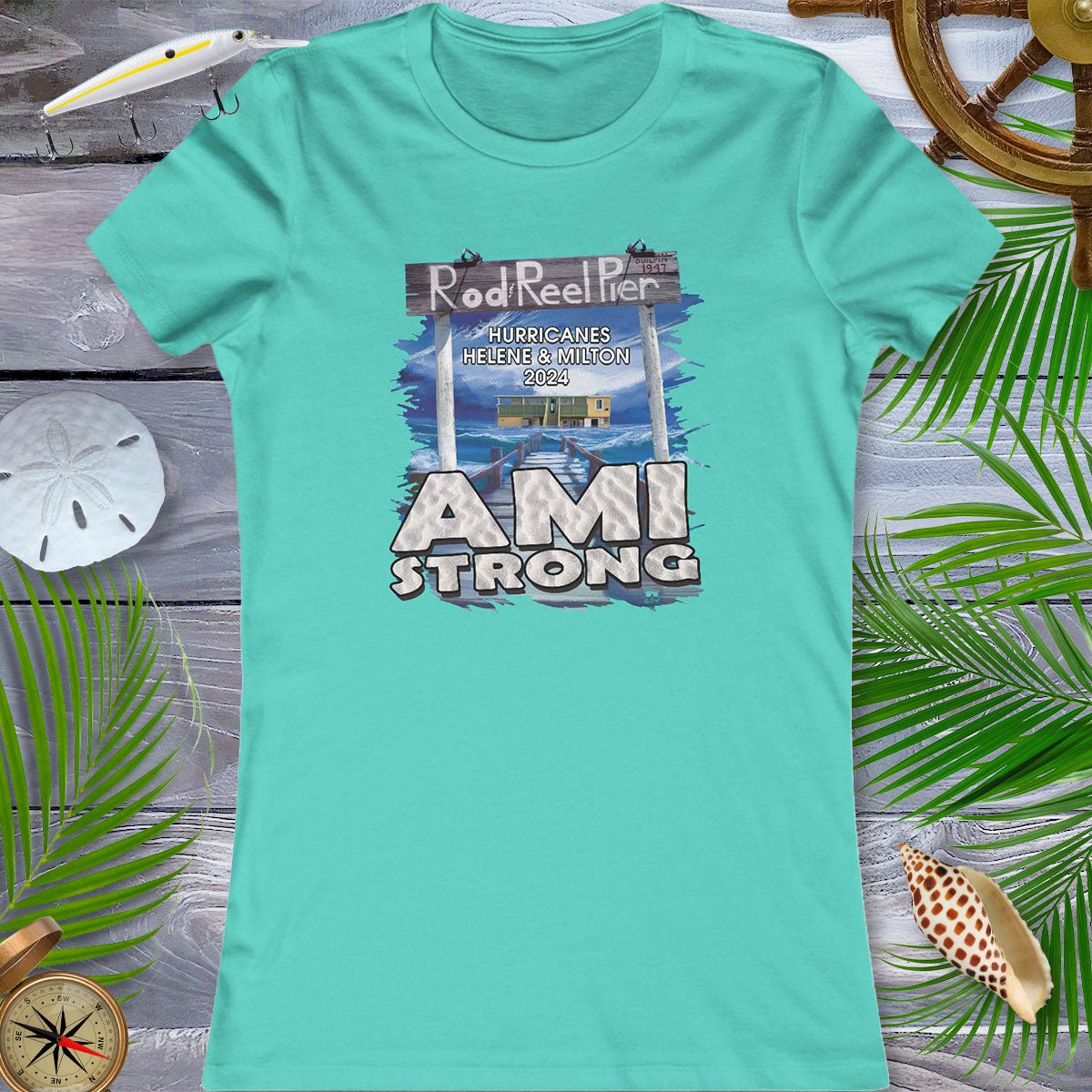 Teal t-shirt with 'AMI Strong' graphic on a wooden surface with beach elements.