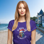 Woman wearing a purple t-shirt with a skull graphic and text on a beach.