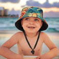 Child wearing a colorful bucket hat with a floral pattern on Waikiki beach