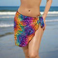 Swimwear model wearing a brilliantly colored tie dye cover up on Daytona Beach