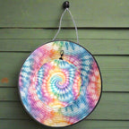 Colorful tie-dye bucket hat hanging by its chinstrap from a nail the wall of a seaside cafe'