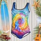 Girls Tie Dye One Piece Youth Swimsuit in front a a rustic nautical wood wall with surfing icons all around