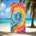 Tie-Dye Beach Towel featuring a classic spiral design with a silhouette of a Seahorse and it's center, hanging on a line in a tropical beach paradise