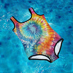 Colorful tie-dye seahorse swimsuit on a blue tiled pool floor