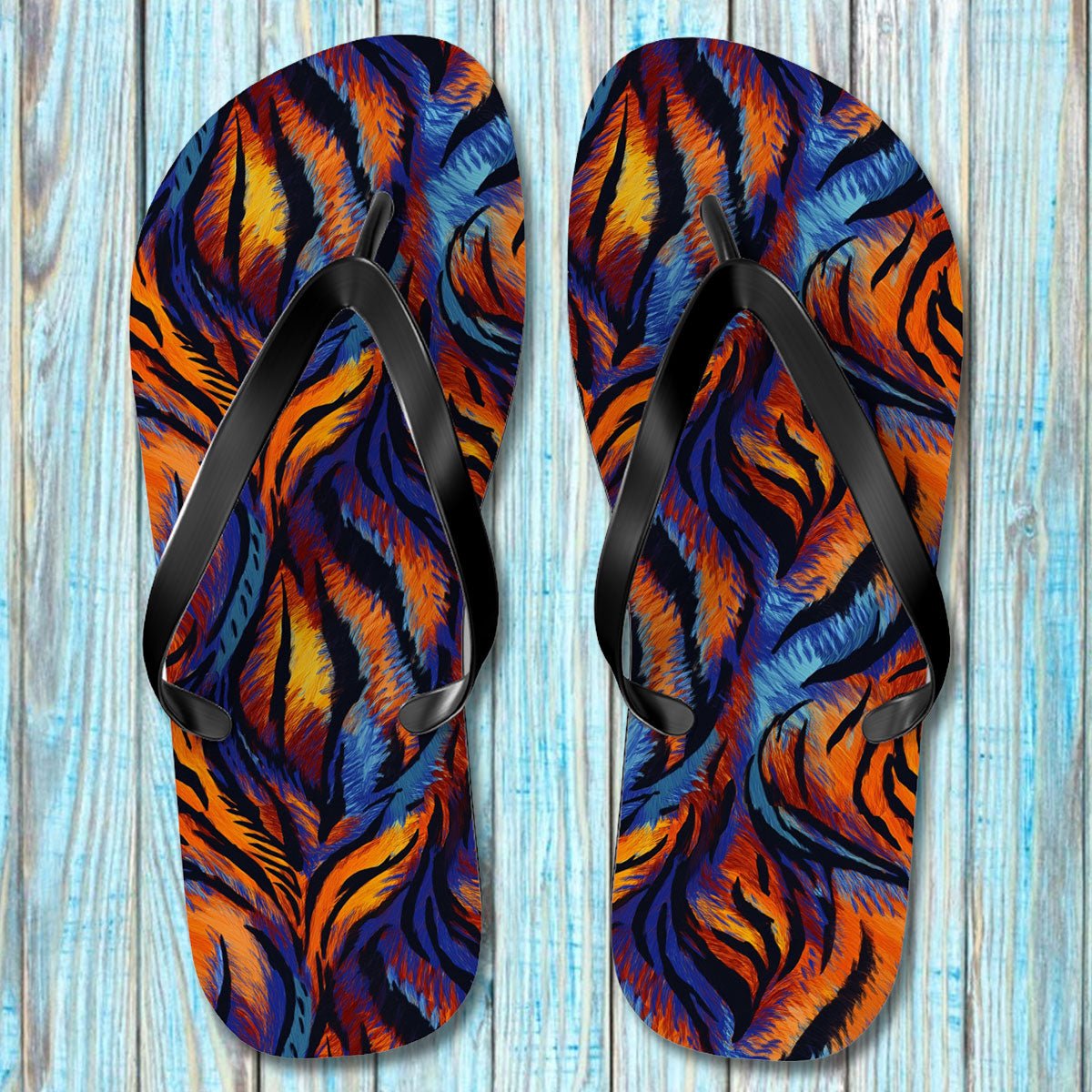 Pair of Tiger Print Flip Flops with a tiger stripe pattern on a wooden surface