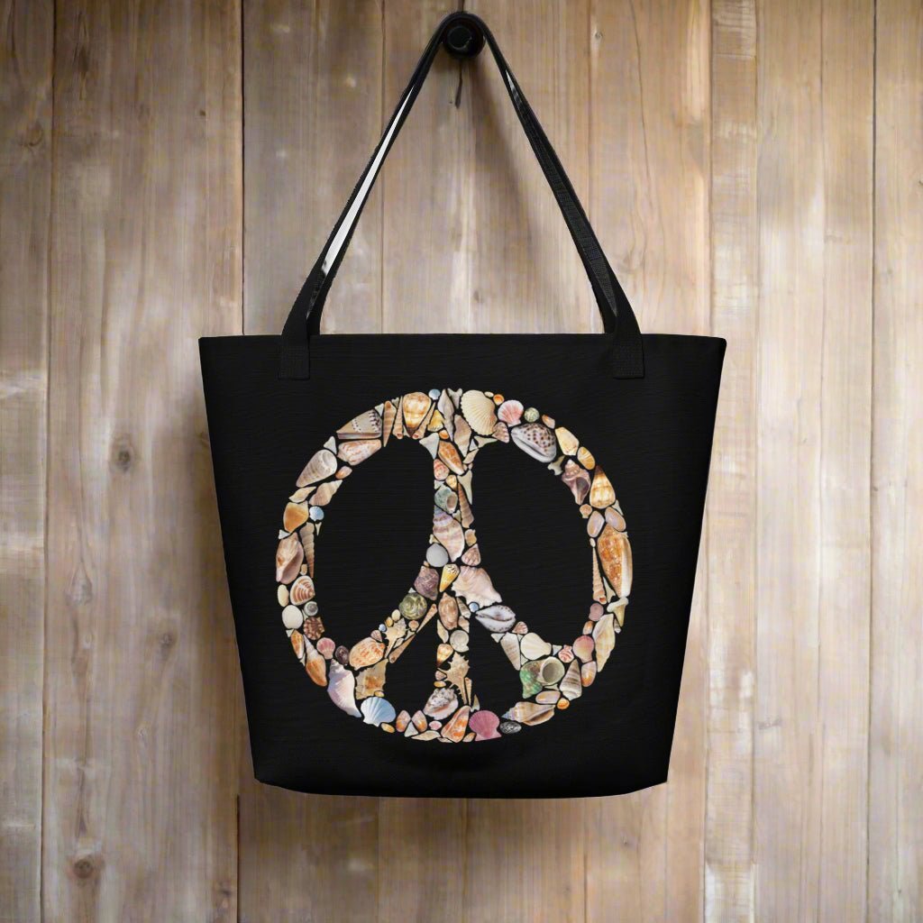 Black Tote Bag with Seashell art forming a Peace Sign hanging on a rustic wood wall in a seaside surf shack