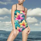 Woman wearing Tropical One Piece Bathing Suit with speghitti straps is standing in the ocean near the beach