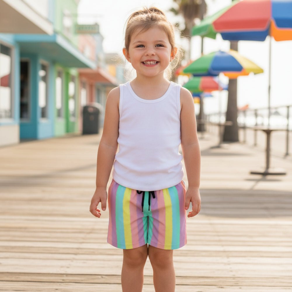 Little girl wearing Tropical Stripes Board Shorts with a drawstring on a beachtown boardwalk.