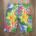 Colorful tropical floral shorts laying flat on nautical wood background 