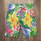 Colorful tropical floral shorts laying flat on nautical wood background 
