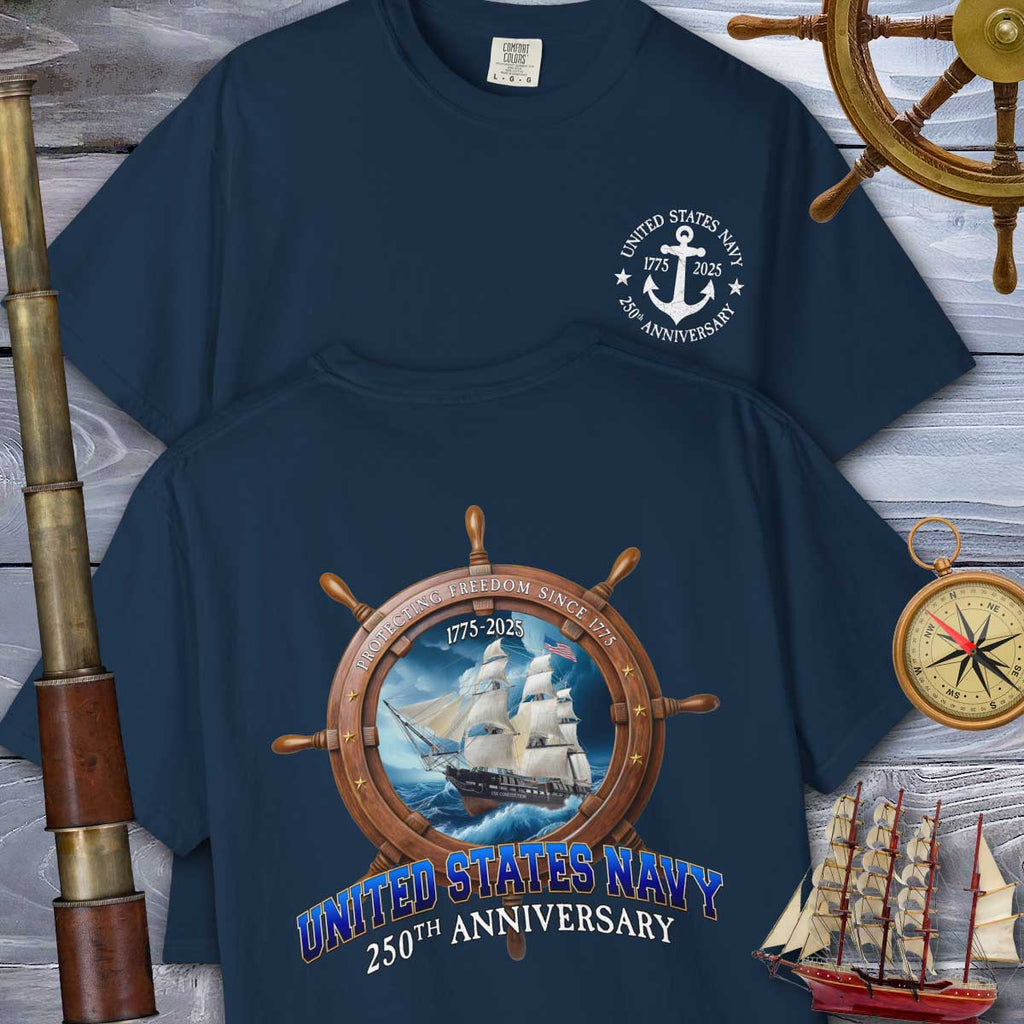 Navy blue Navy Anniversary T-Shirt with United States Navy 250th Anniversary design on a wooden background with ship and compass elements.