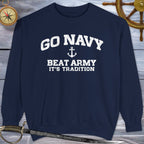 Navy blue Go Navy Sweatshirt with 'GO NAVY BEAT ARMY IT'S TRADITION' text on a wooden background with nautical items.