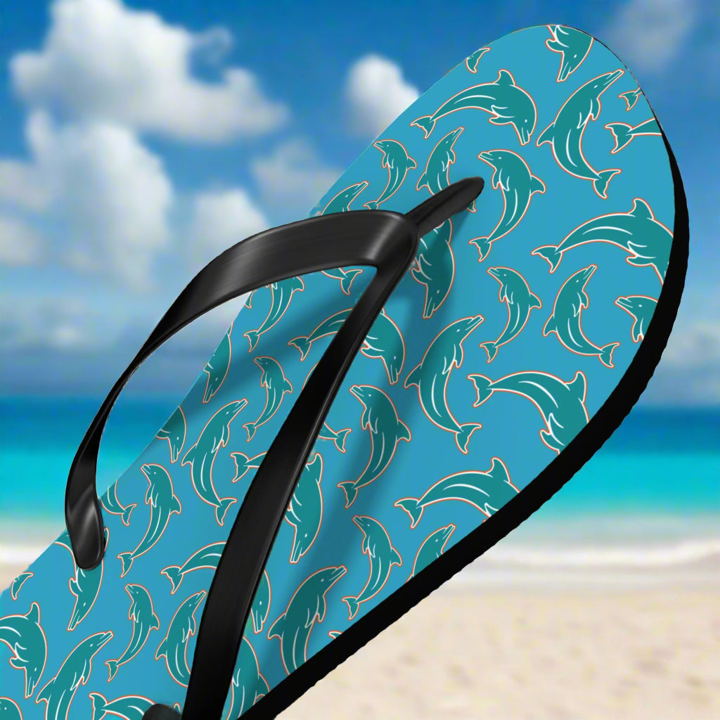 Flip-flop with dolphin pattern in team colors on a blue background at the beach