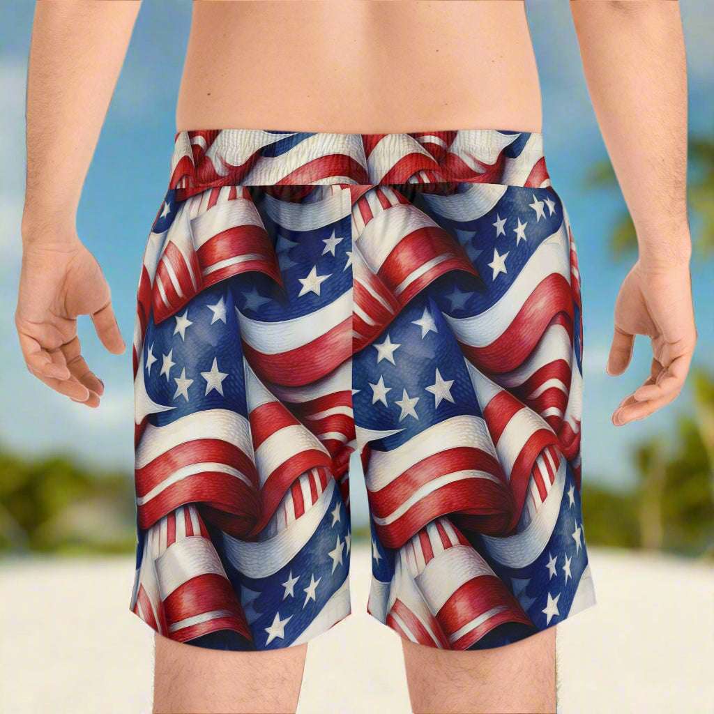 guy hanging out on the beach facing away showing the back of his USA Flag Beach shorts