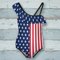 One-piece swimsuit with American flag design on a rustic nautical wood background