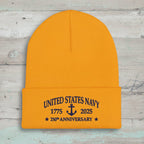 A bright gold ribbed knit Navy Anniversary beanie hat with a folded cuff featuring navy blue embroidered text that reads 'UNITED STATES NAVY 1775 2025 250th ANNIVERSARY' with an anchor in the center.