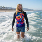 Surfer dude with long stringy blond hair walking through the waves in Ventura Beach wearing a colorful Clown fish-themed
