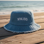 Blue denim bucket hat with WWJBD on a beachside boardwalk