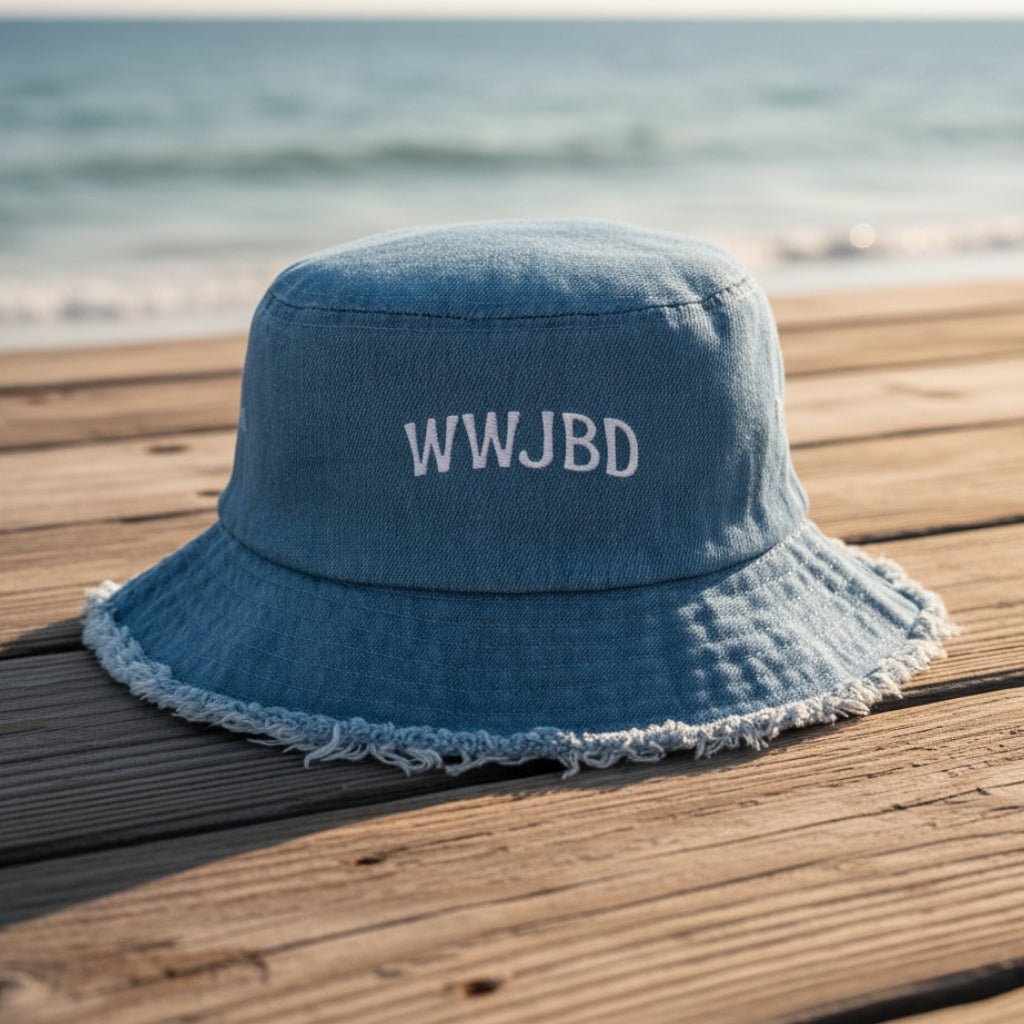 Blue denim bucket hat with WWJBD on a beachside boardwalk