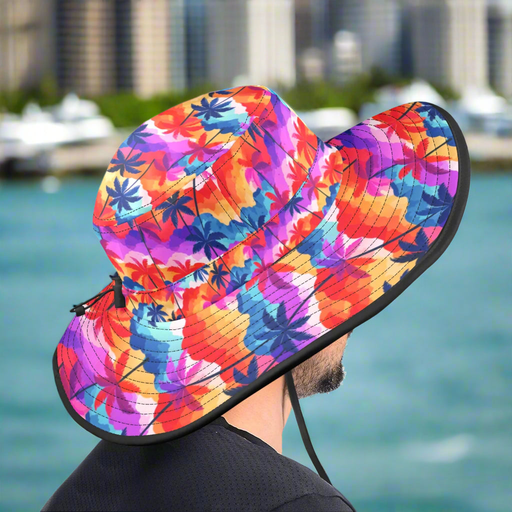 Colorful floral-patterned sun hat with a black brim worn by a guy sitting on the dock of the bay.