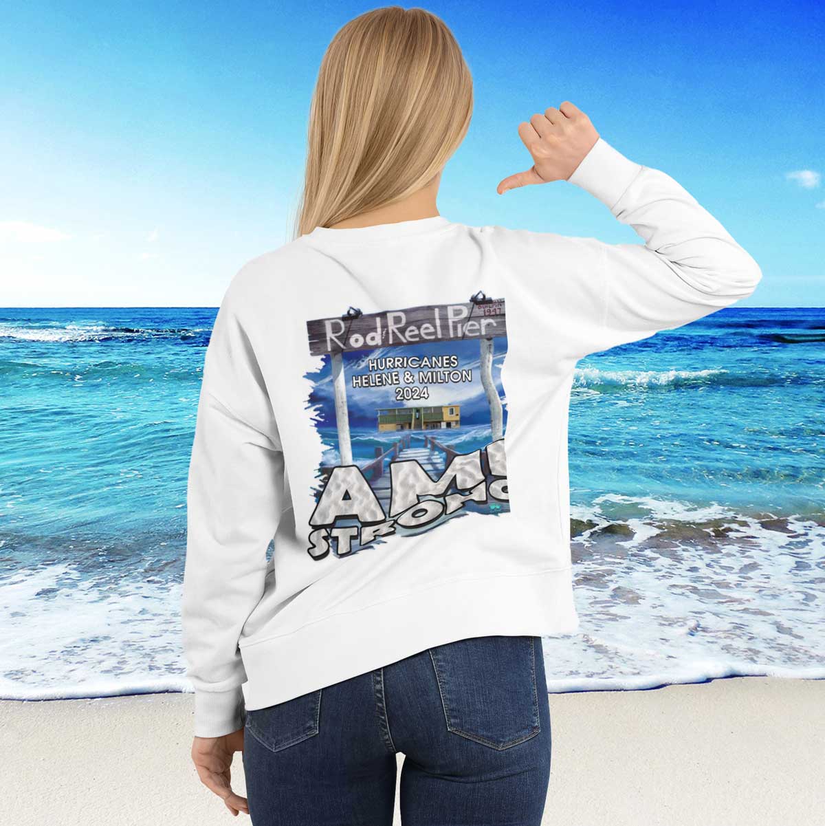 Person wearing a white hoodie with a graphic design on the beach