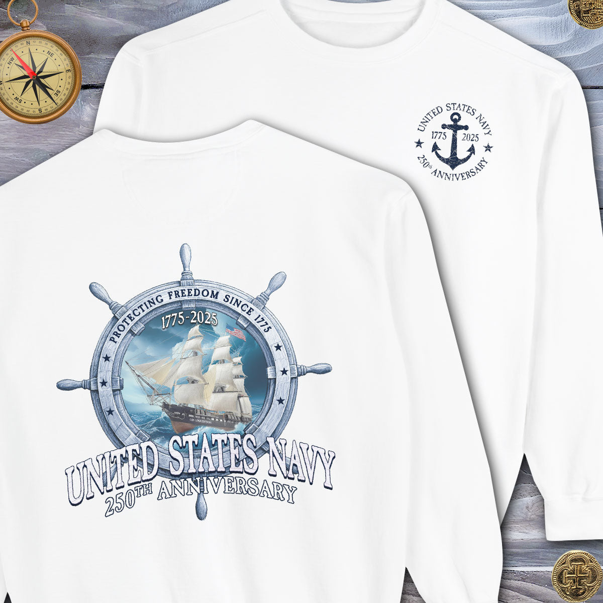 White sweatshirt with United States Navy 250th Anniversary design featuring a ship and wheel on a wooden background.
