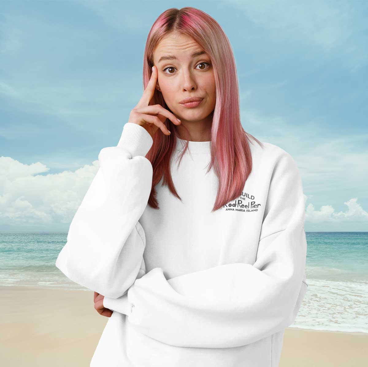 Person wearing a white sweatshirt with text on it, standing on a beach.