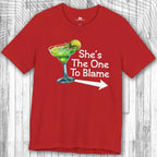 Red Margarita Party Tee with a graphic of a green margarita and text 'She's The One To Blame' on a wooden surface.